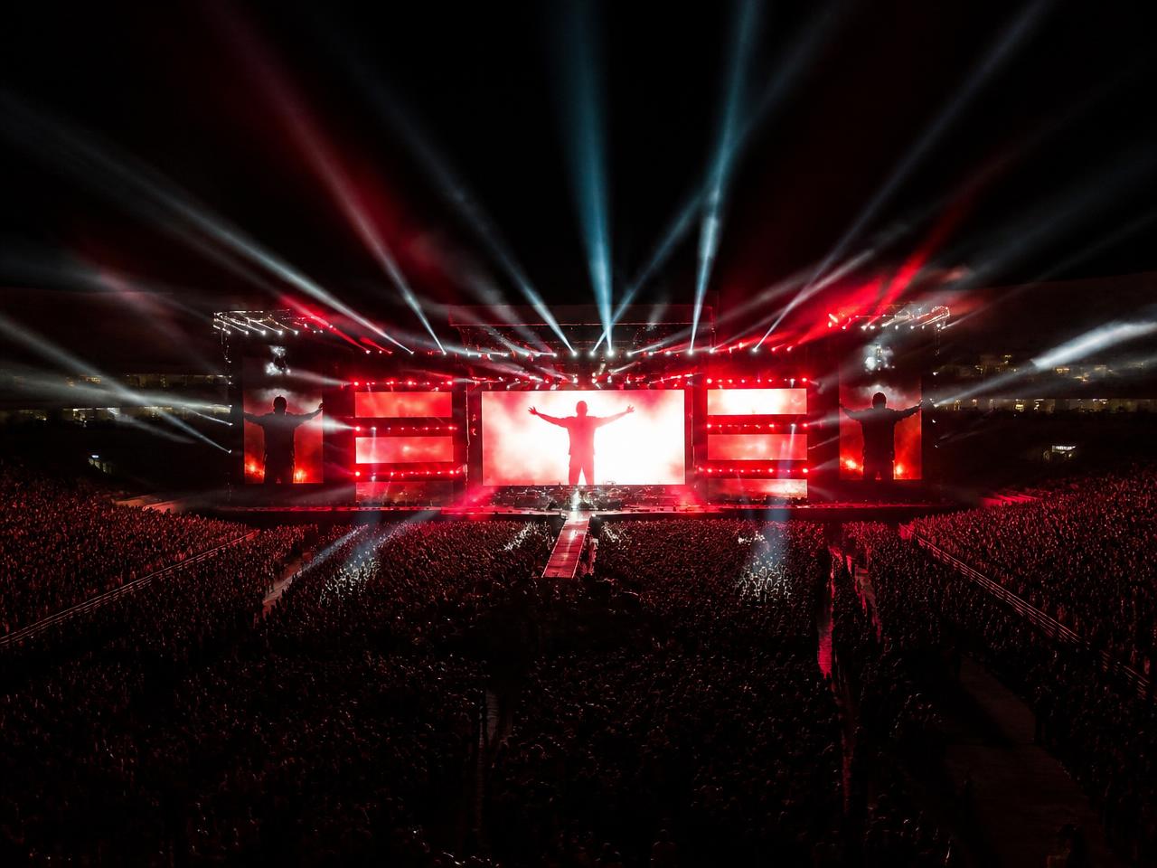 Headline stage lit red inside a packed stadium