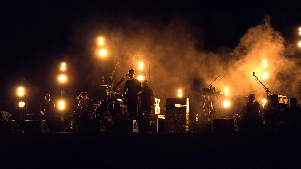 Backlit stage silhouettes and warm lights during a live band set